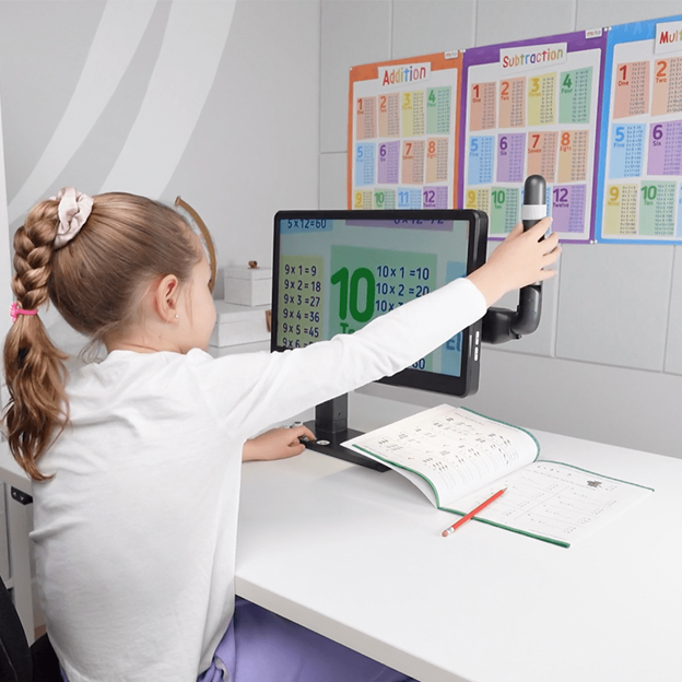 Child using MirrorPad Pro distance camera to view classroom board content clearly from a desk, improving visibility in a learning environment.